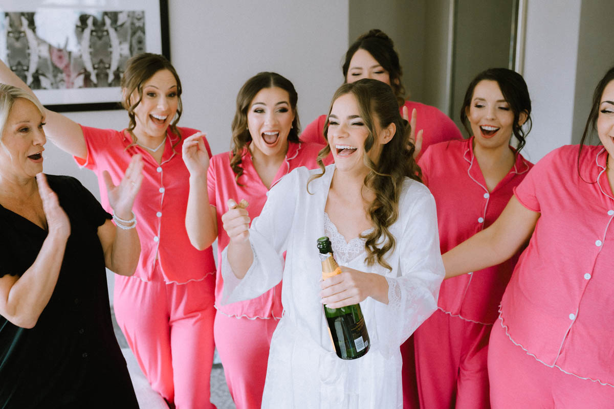 Popping the Champagne with the bridesmaids