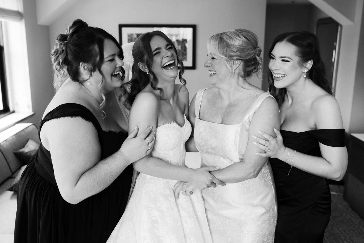 Bride laughing with her sisters
