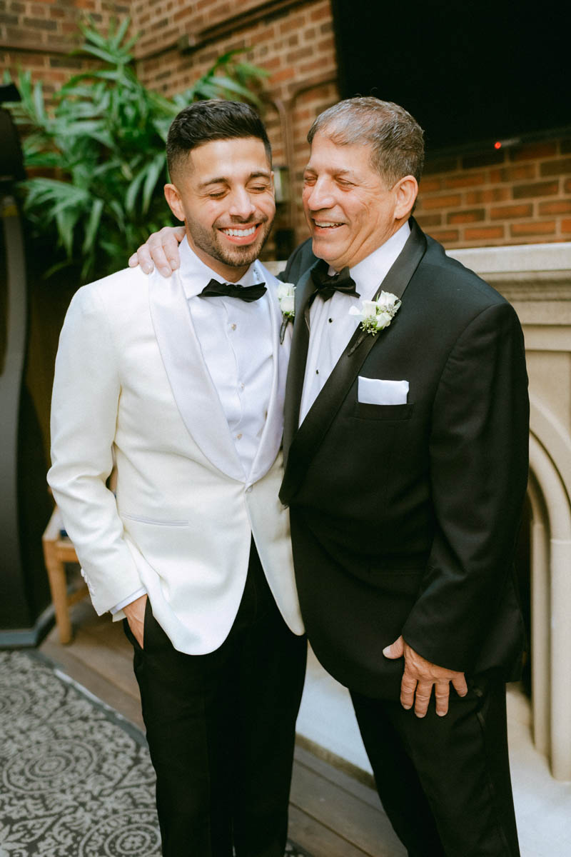 Groom and his dad share a laugh at their Greek wedding day