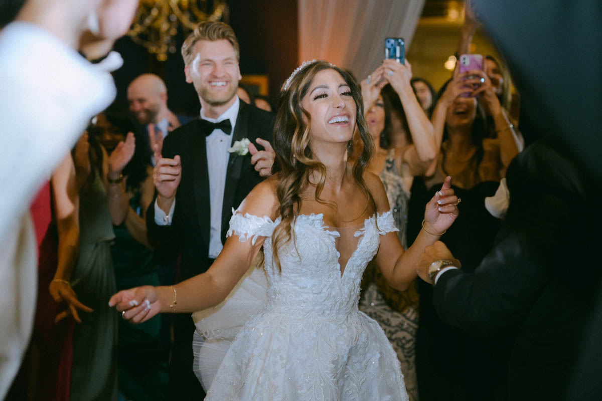 Bride dancing with wedding guests during a Greek wedding celebration