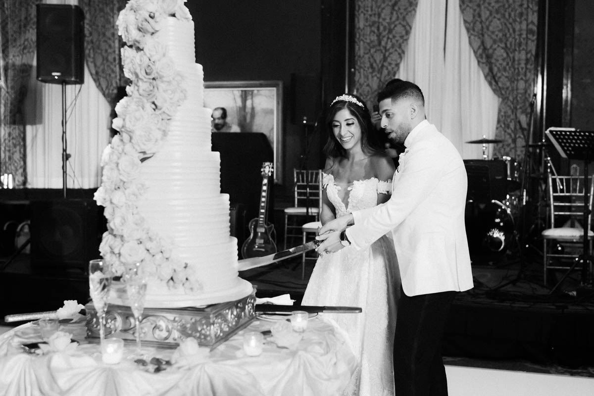 Black and white bride and groom dancing near their wedding cake