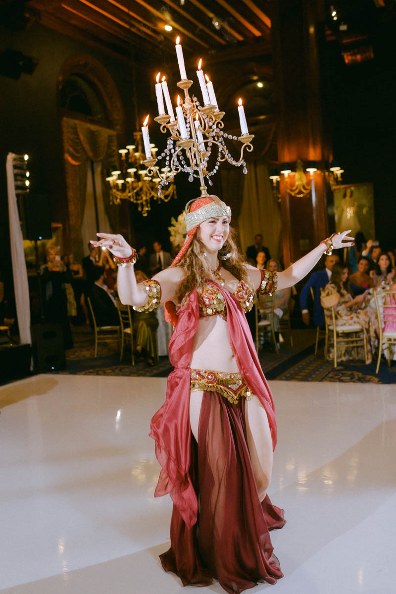 Belly dancer with chandelier dancing with wedding guests