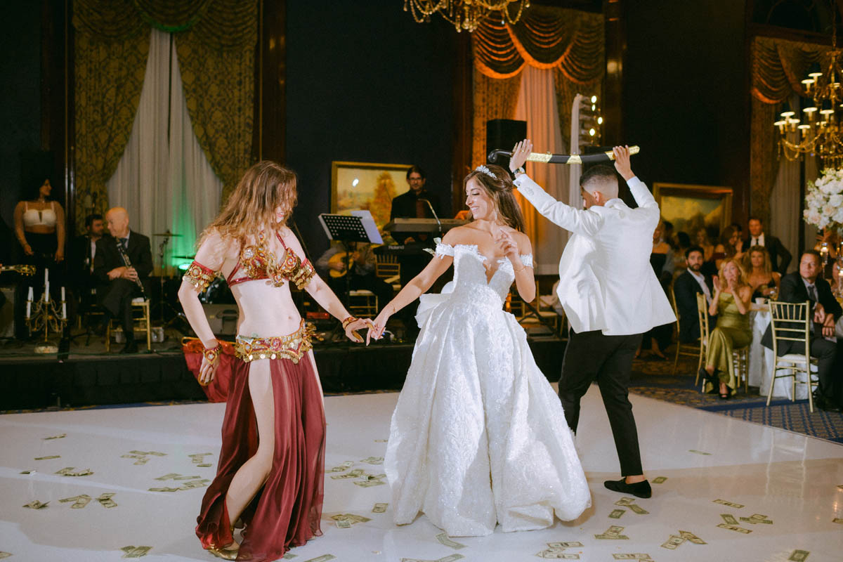 Bride dancing with friends beneath chandeliers at the Union League Club