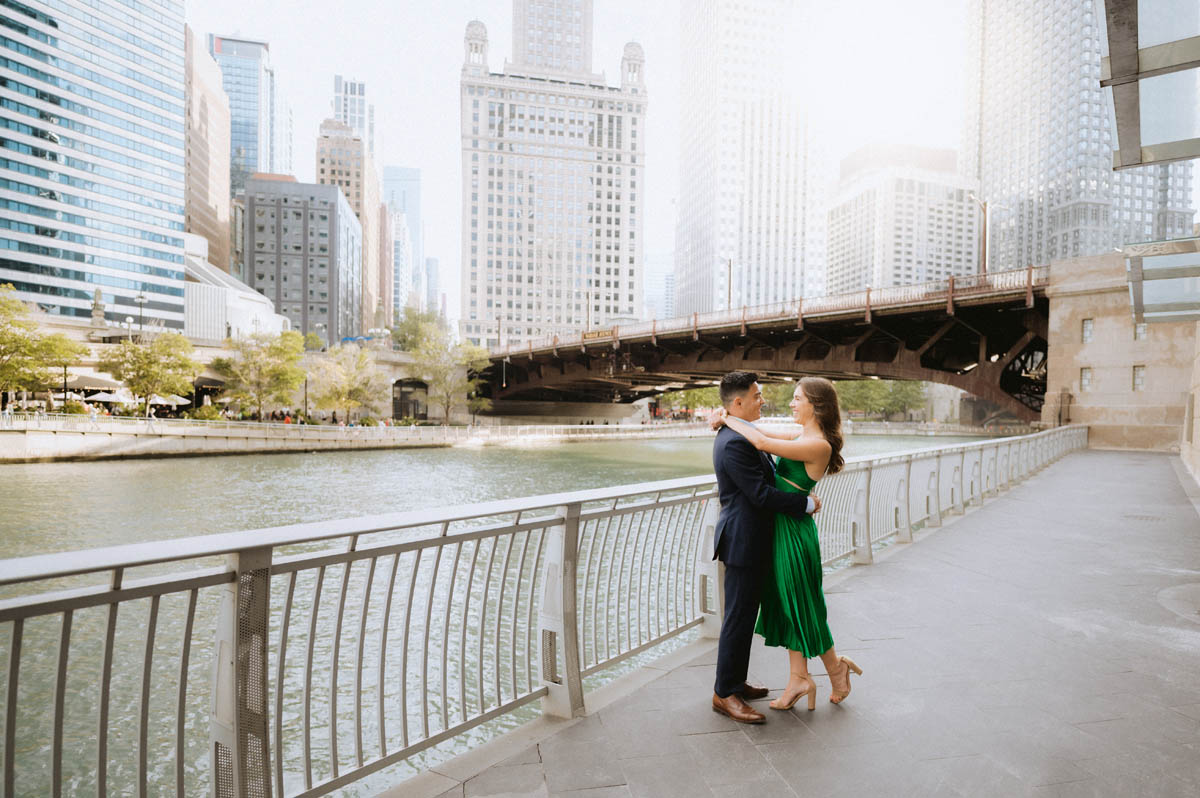 Chicago engagement photo of a couple kissing along the Chicago River with the downtown skyline