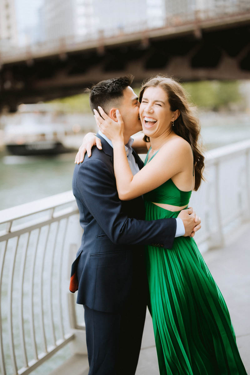 Romantic Chicago engagement photo of a couple embracing and laughing on a city bridge