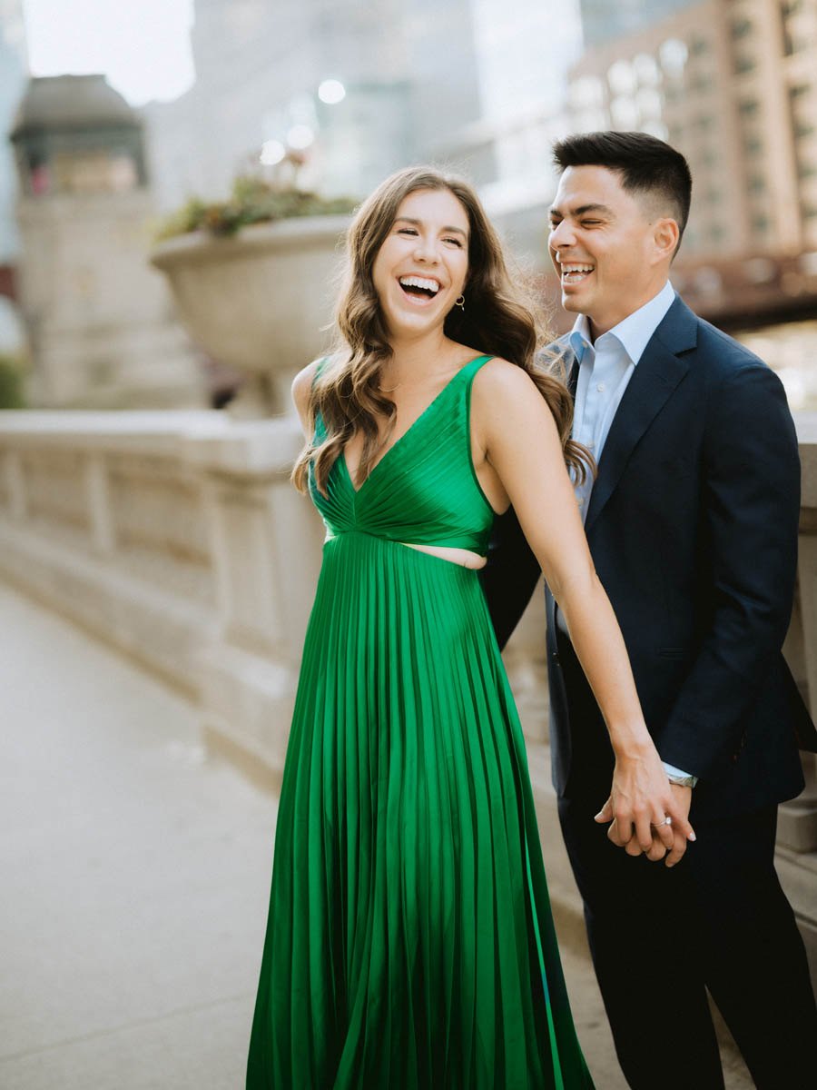 Candid Chicago engagement photo of a couple laughing together by the river