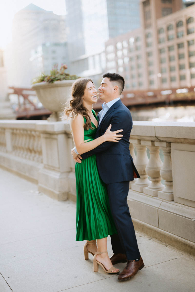 Romantic Chicago engagement photo of a couple embracing and laughing on a city bridge