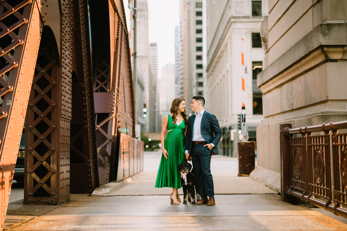 Chicago engagement photos of a couple walking with their dog among downtown architecture