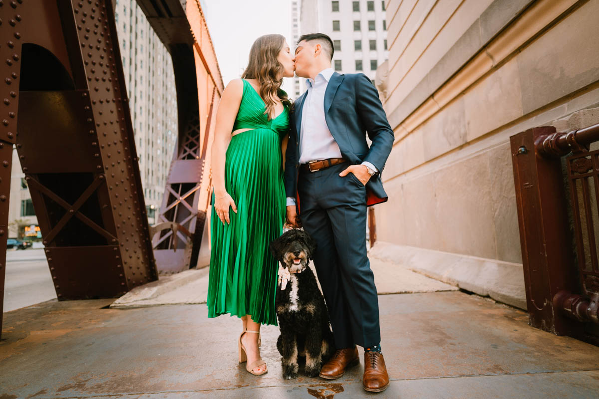 Chicago engagement photo of a couple walking with their dog through downtown Chicago