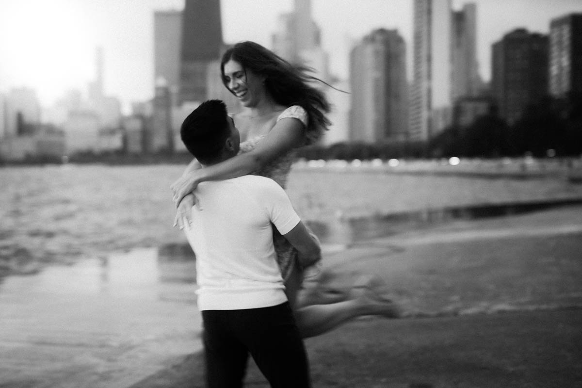 Black and white cinematic motion blur Chicago engagement photo of a couple embracing by the lake