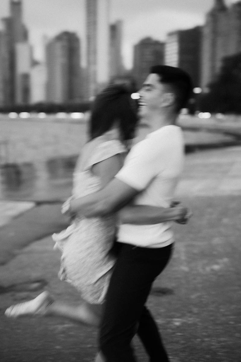 Black and white cinematic motion blur Chicago engagement photo of a couple embracing by the lake
