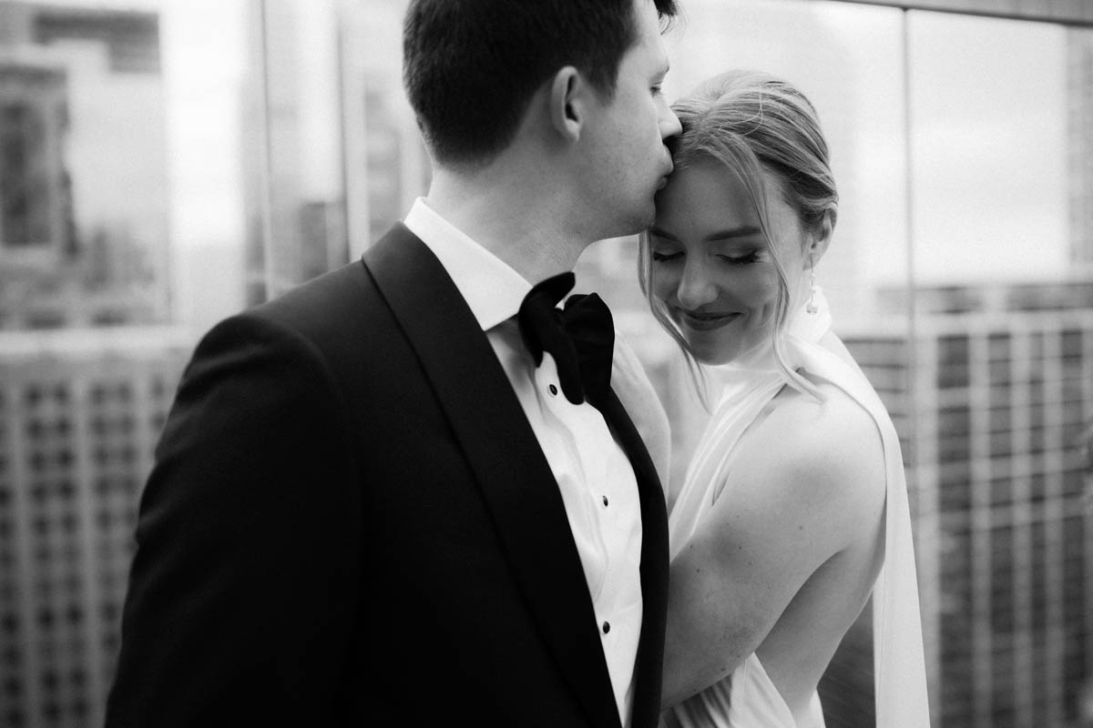 Black and white close-up portrait of bride and groom embracing