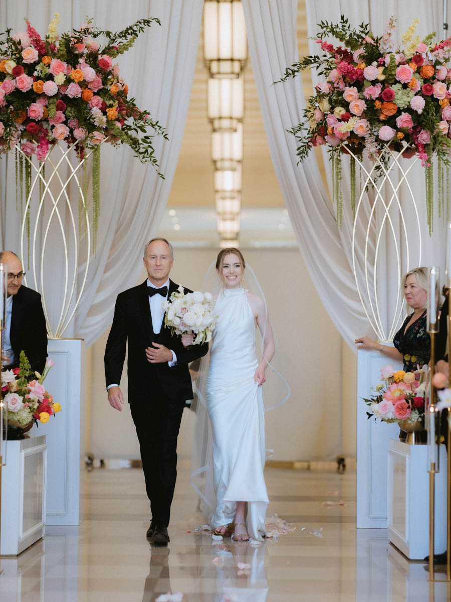 Bride walking down the aisle toward her groom during a wedding ceremony at the Old Post Office Chicago