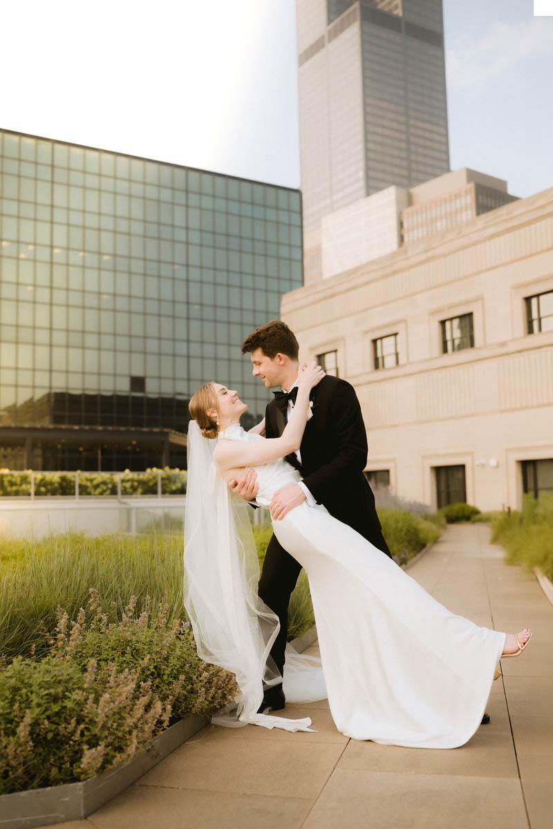 Bride and groom embracing on the rooftop of the Old Post Office with the Sears Tower in the background