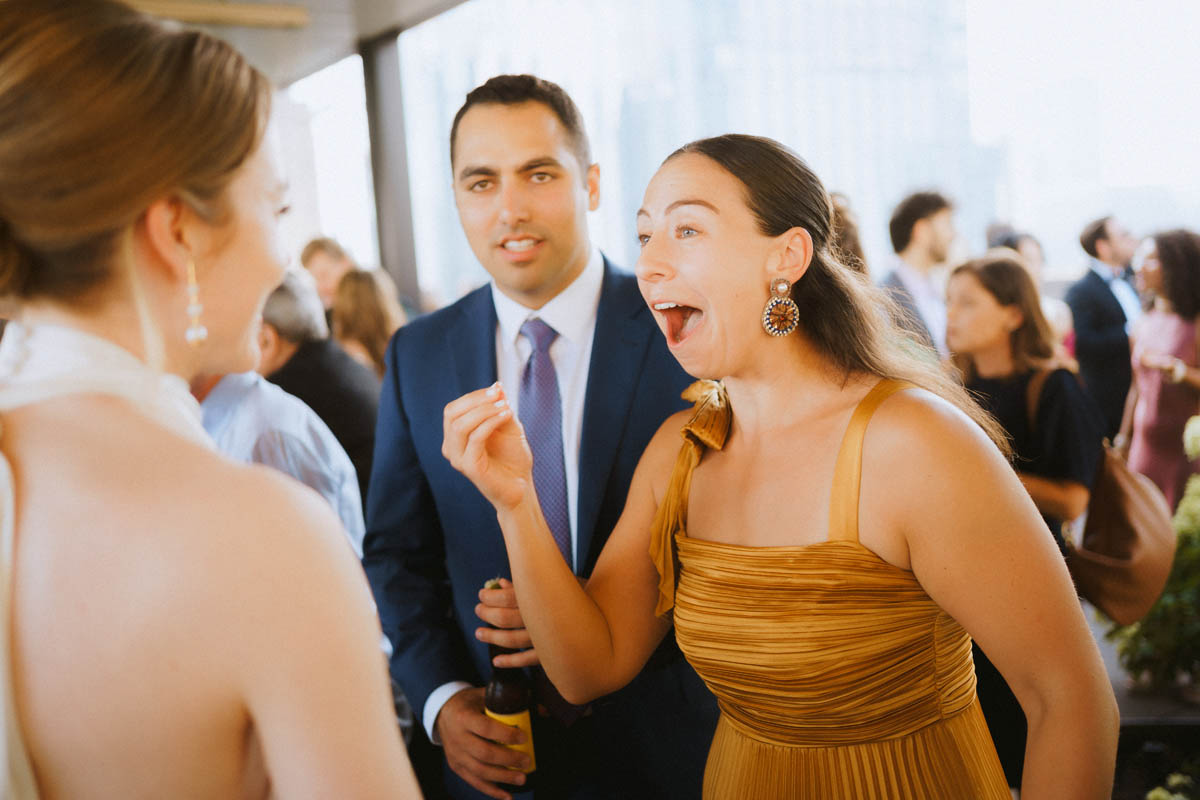 Wedding guests laughing and celebrating together at the rooftop cocktail hour