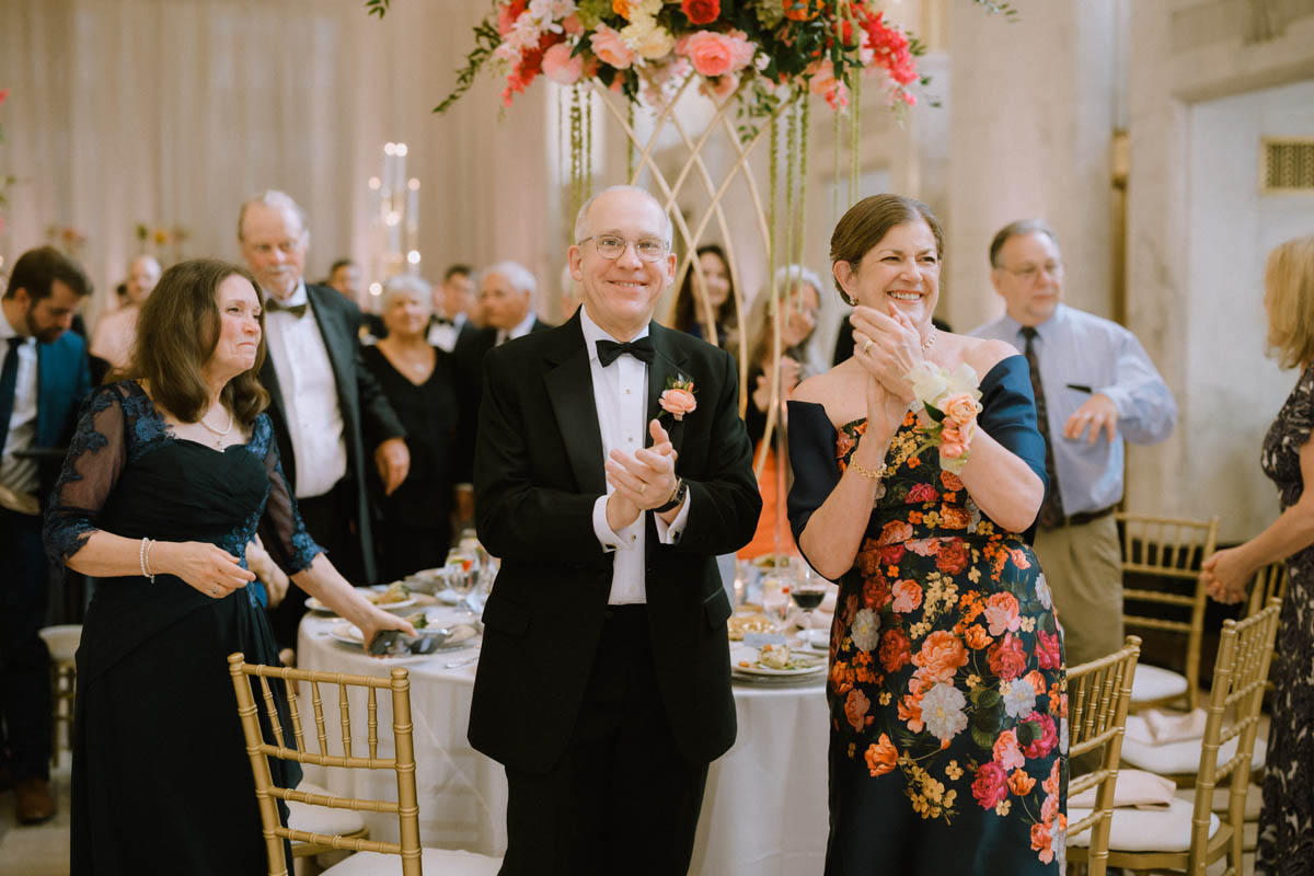 Groom's parents cheering as couple enter reception