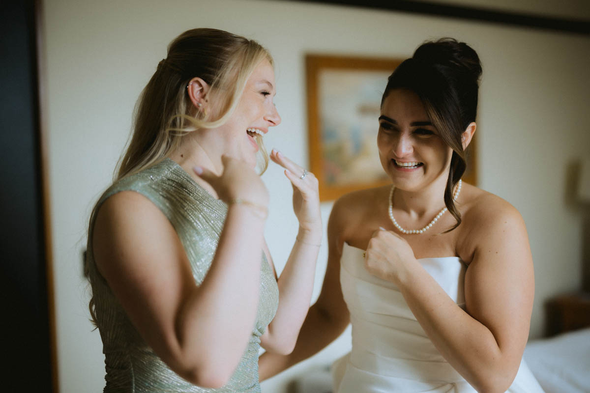 Bride and friend sharing a candid moment while getting ready for a Chicago wedding