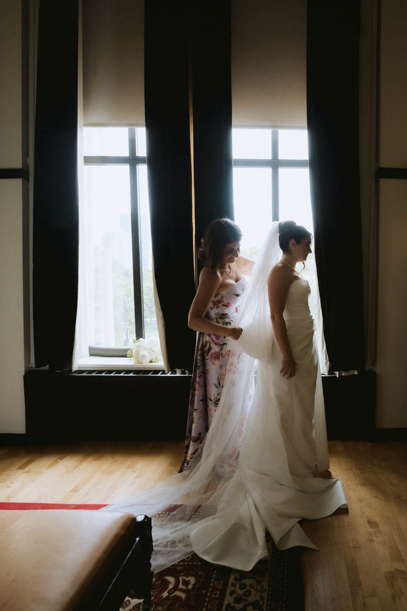 Bride standing near a window while getting ready for her wedding in Chicago