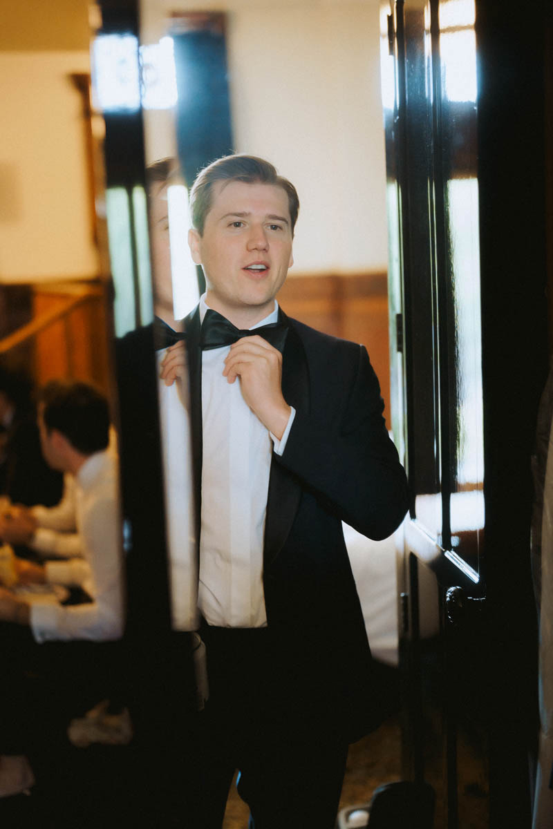 Groom adjusting his suit during wedding preparations in Chicago