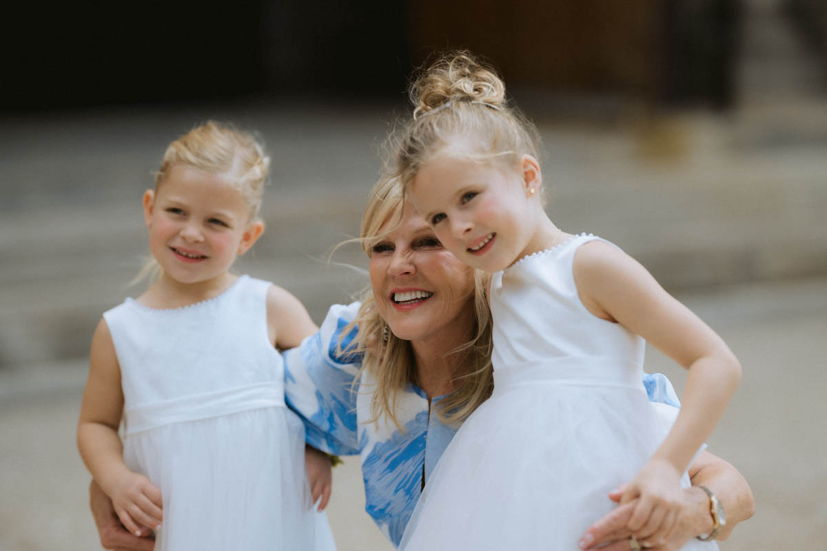 Groom's mom posing with the flower girls