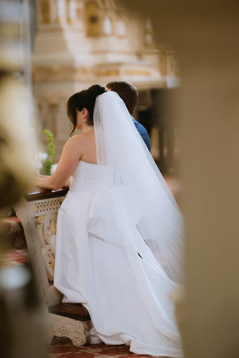 Bride kneeling at the alter of wedding ceremony