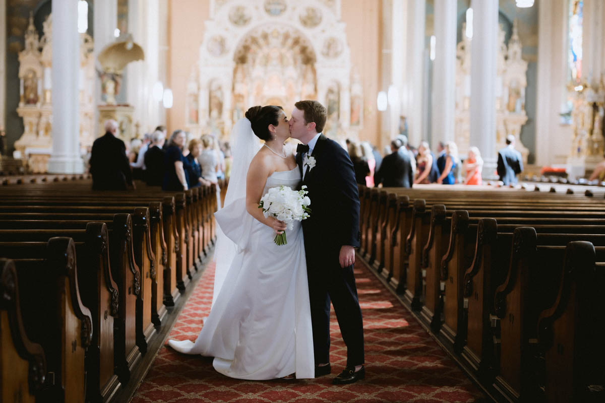 Bride and groom kiss down the aisle at wedding ceremony