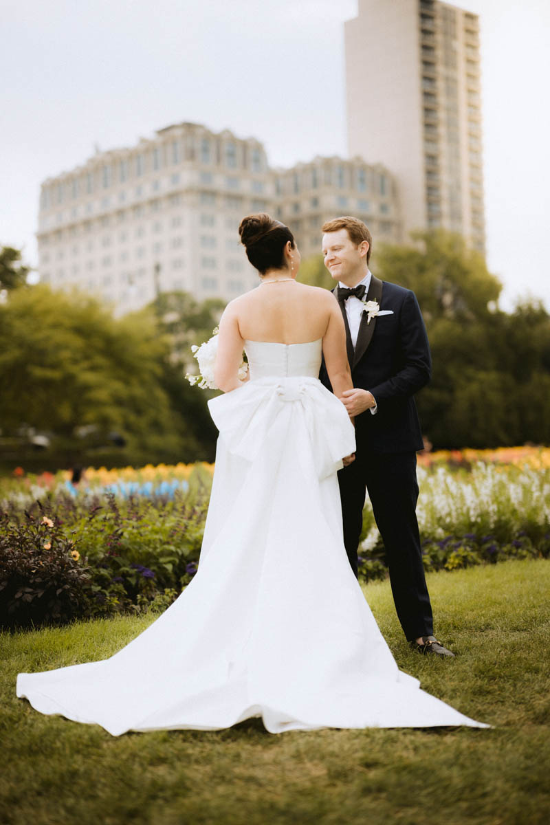 Newlywed couple walking together through Lincoln Park after their wedding ceremony