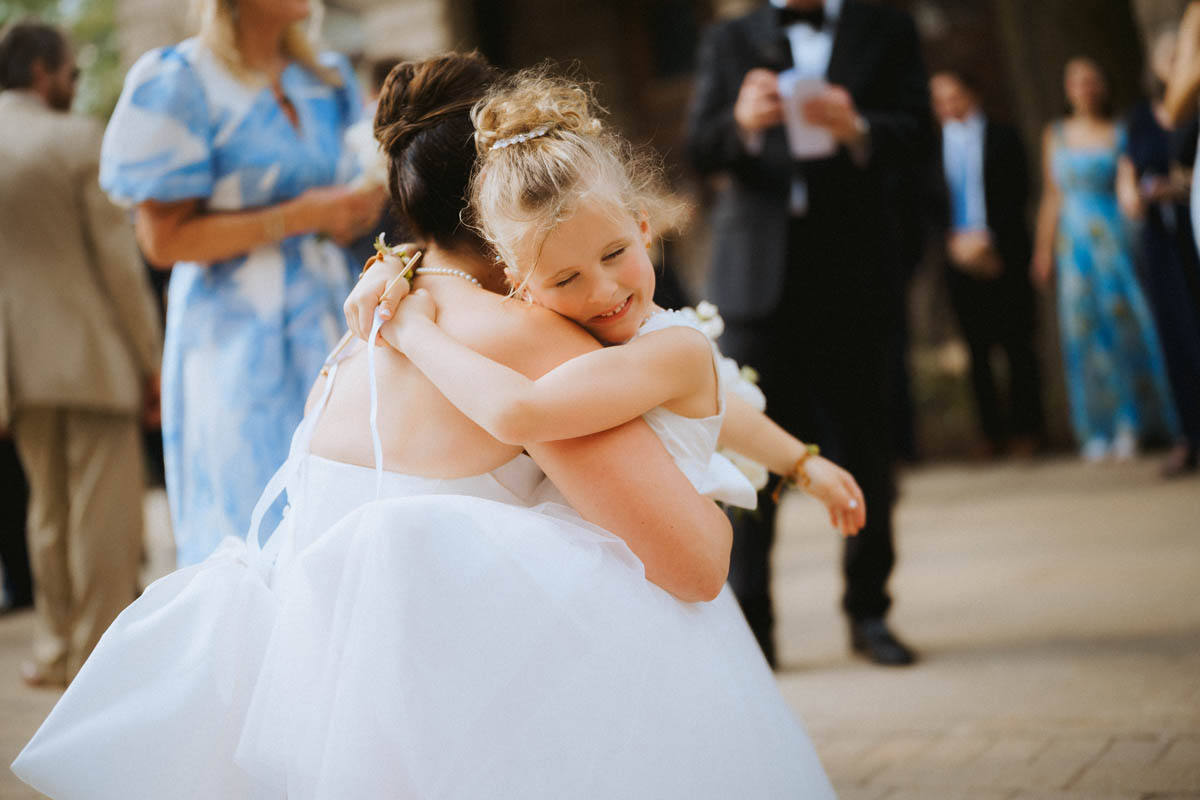Bride hugs little flower girl
