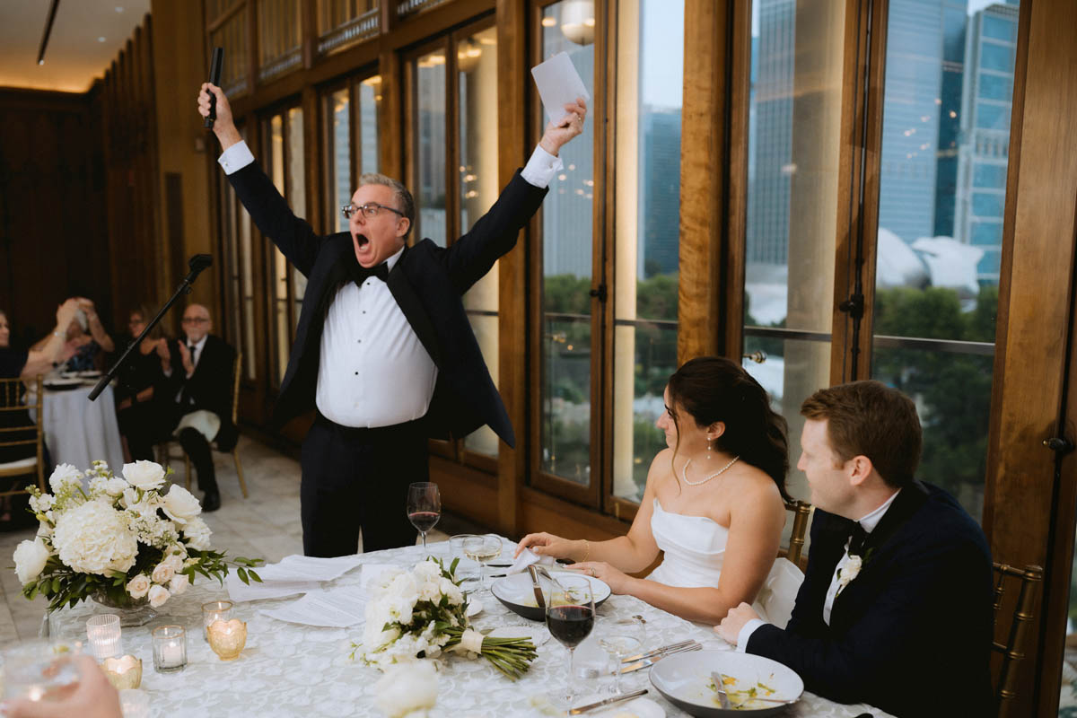 Father celebrating with his arms raised during the Chicago Athletic Association Hotel wedding reception
