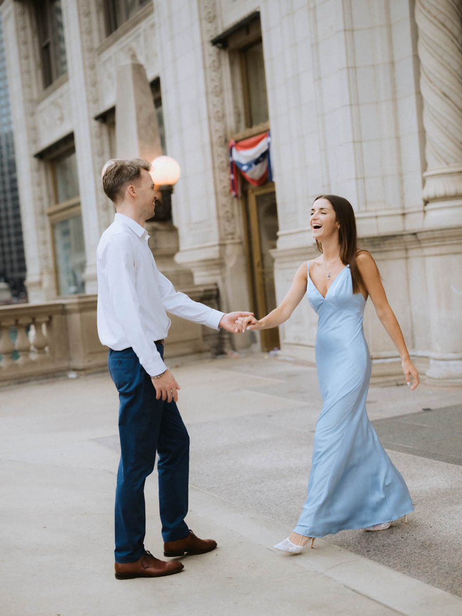 Engaged couple dancing by the Wrigley Building