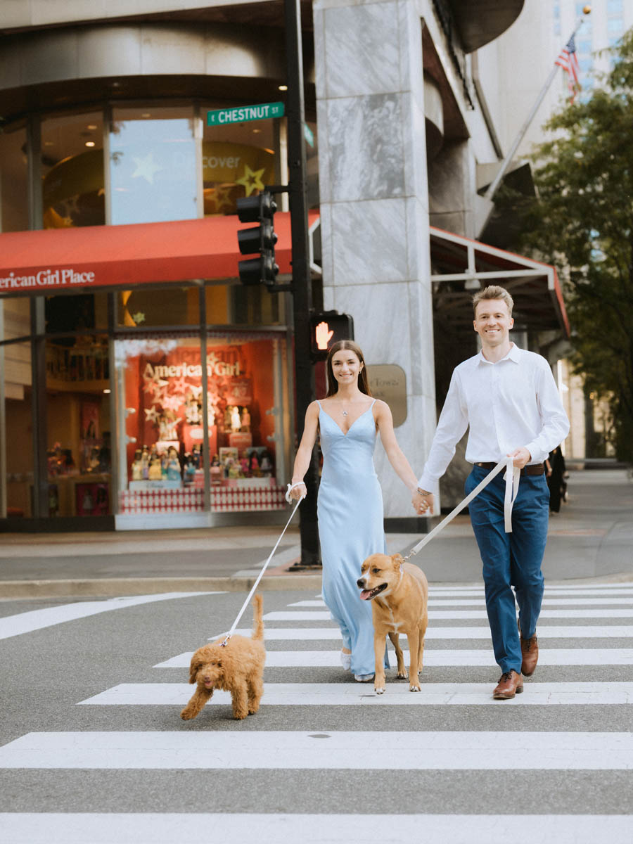 Engaged couple walking with dogs